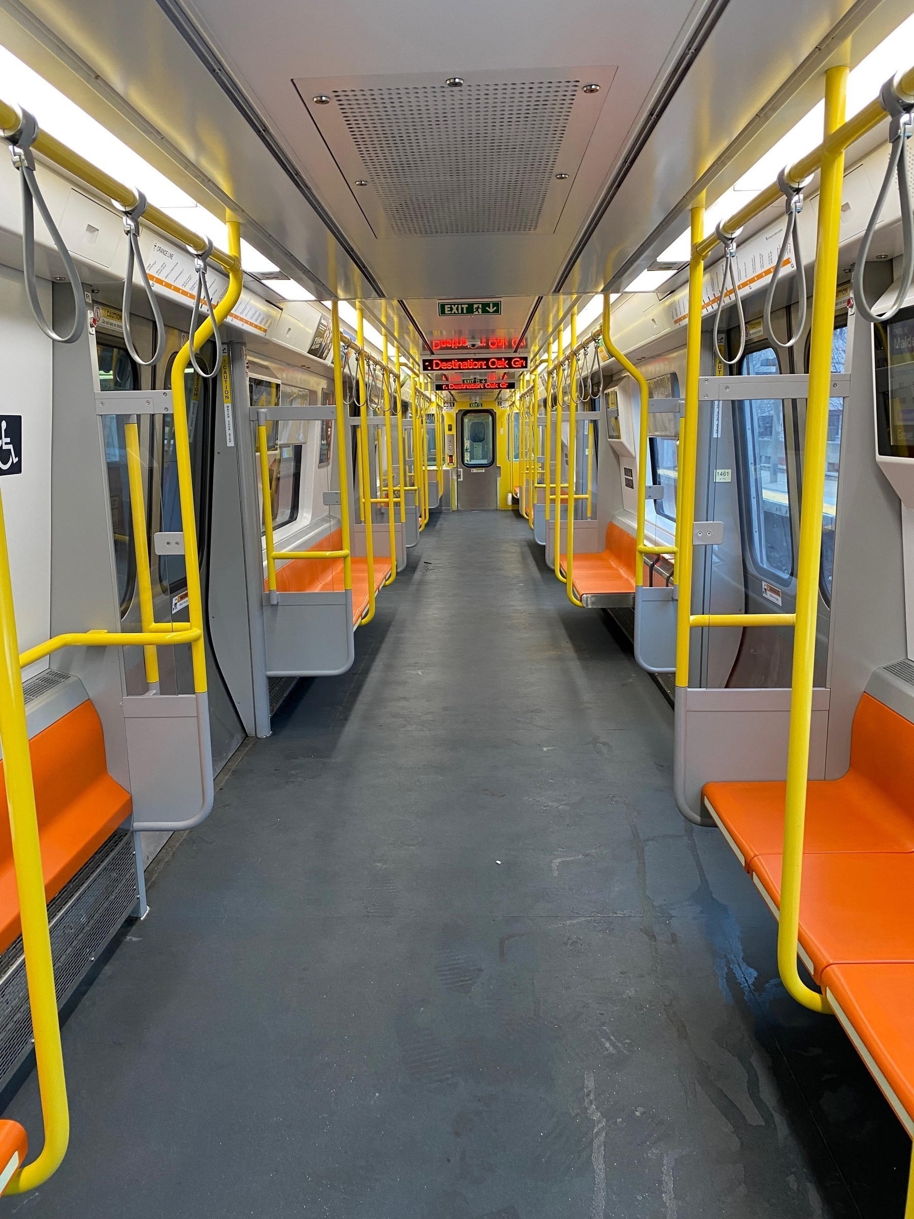 View of an empty Orange Line subway car from one end.