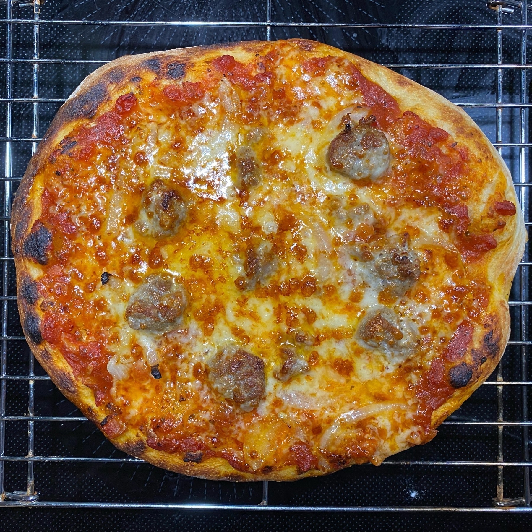 Small pizza on a cooling rack from directly above.