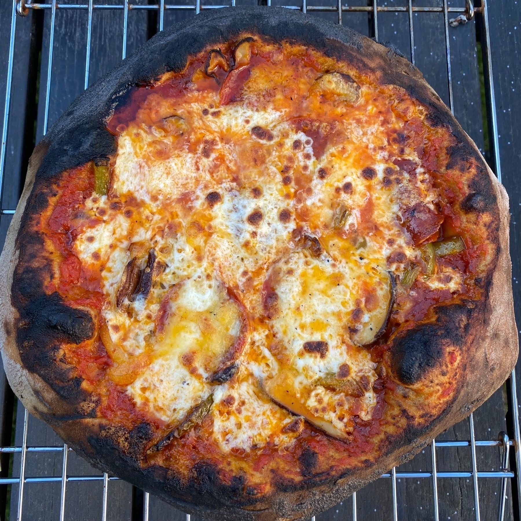 Small pizza on a cooling rack.