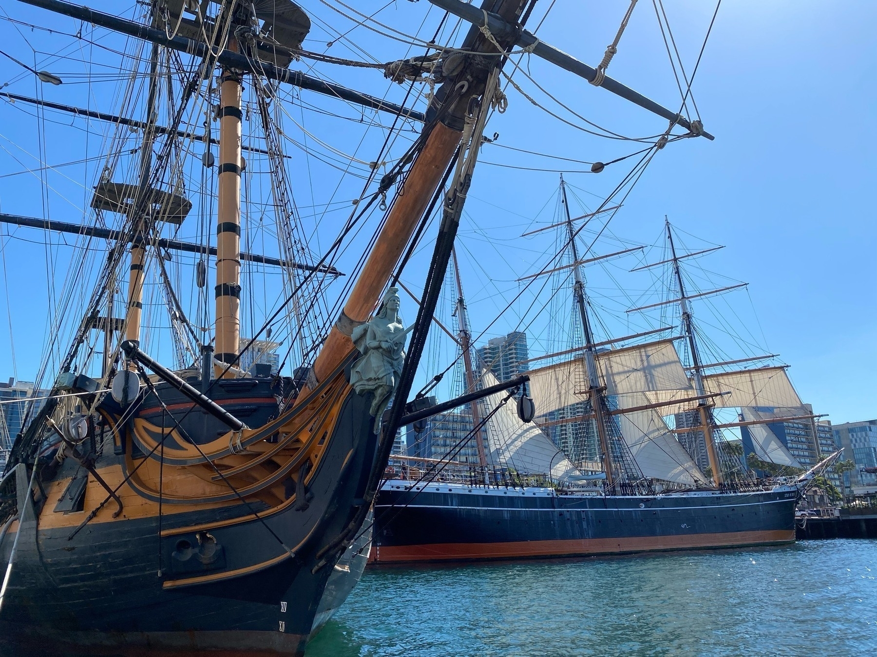 View of rigged ships, the bow of the Suprise on the left, the Star of India in the background on the right, with a few of the lower sails spread.