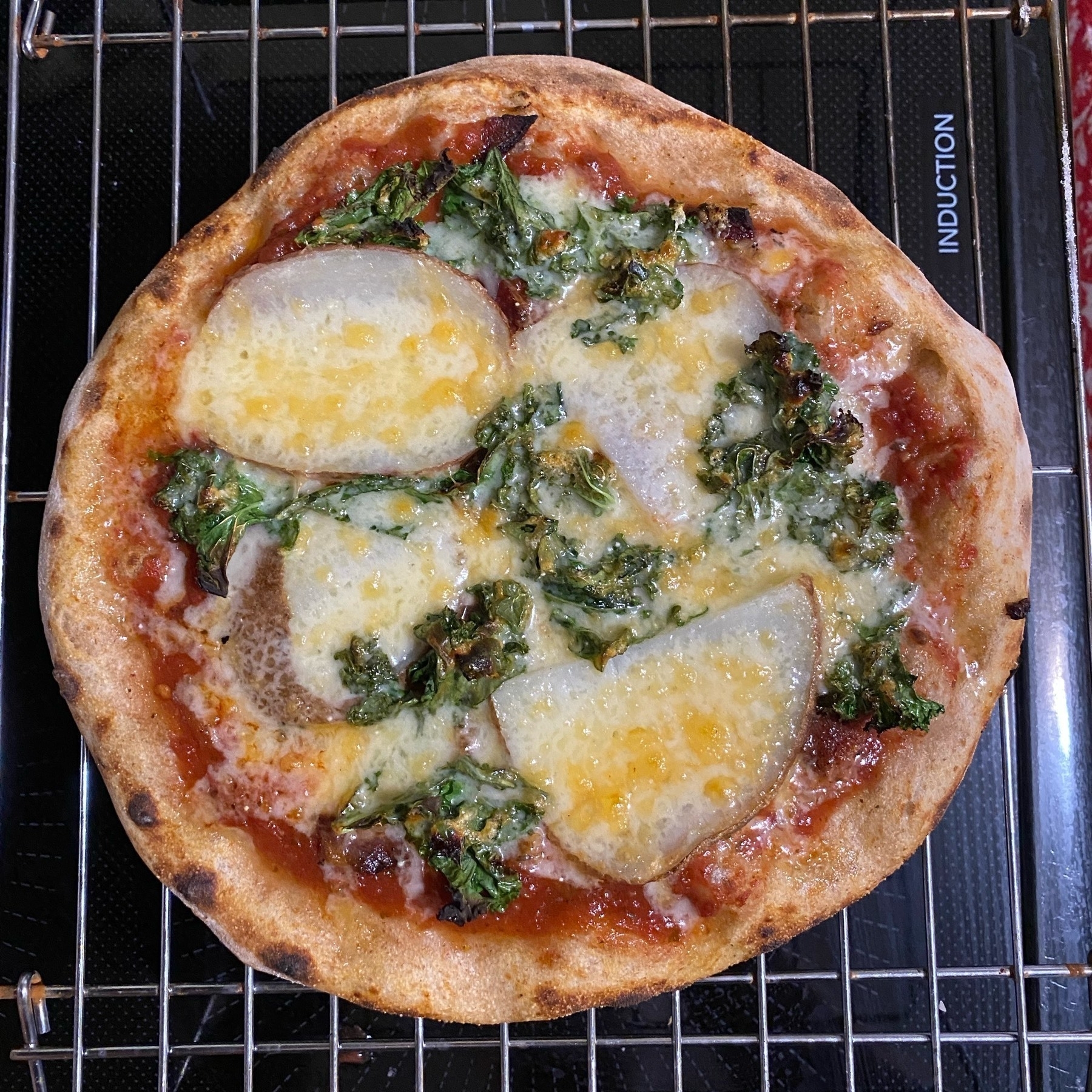 Close up of a small pizza on a cooling rack.