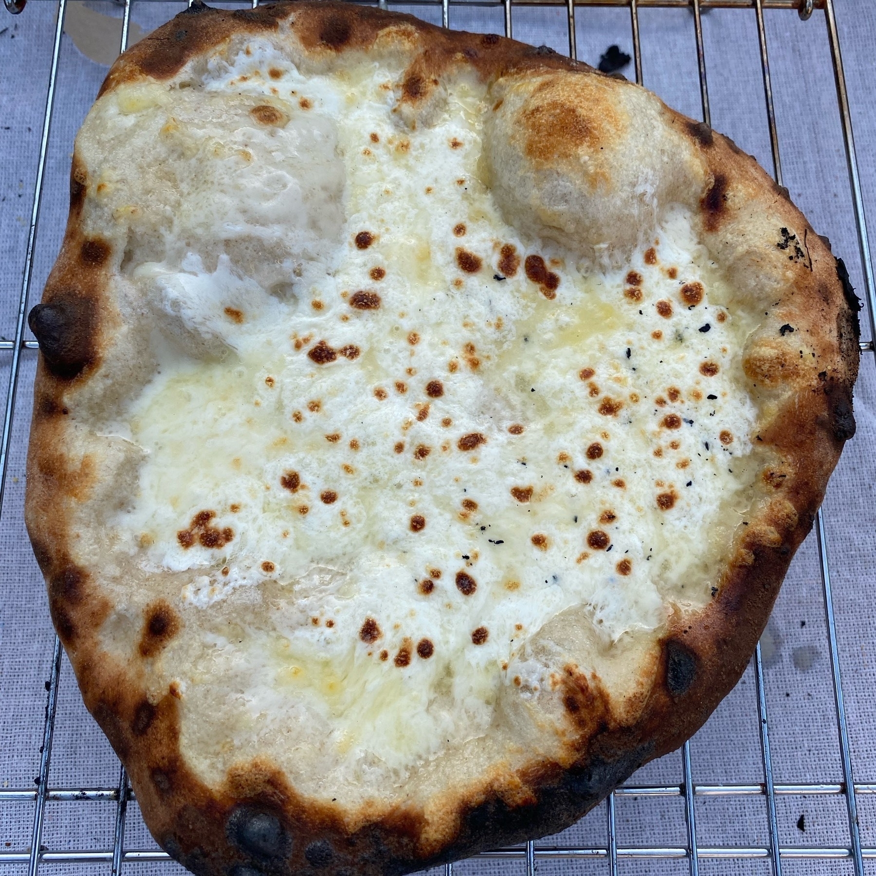 Small white pizza on a cooling rack