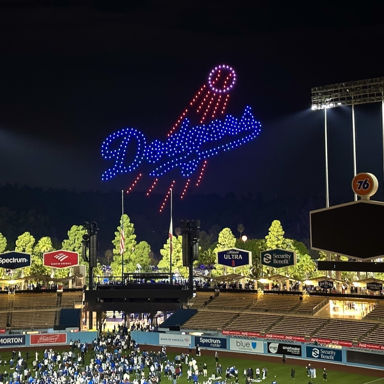 Dodger Stadium at night, people on field watching a drone display.