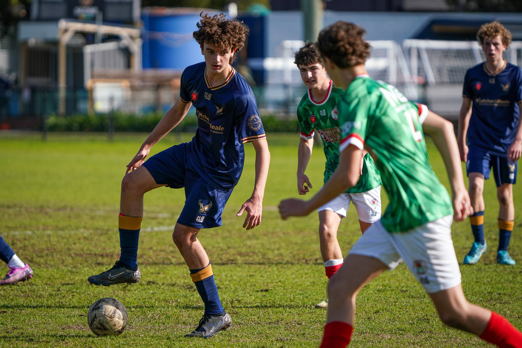 A group of young soccer players are actively engaged in a match on a grassy field.