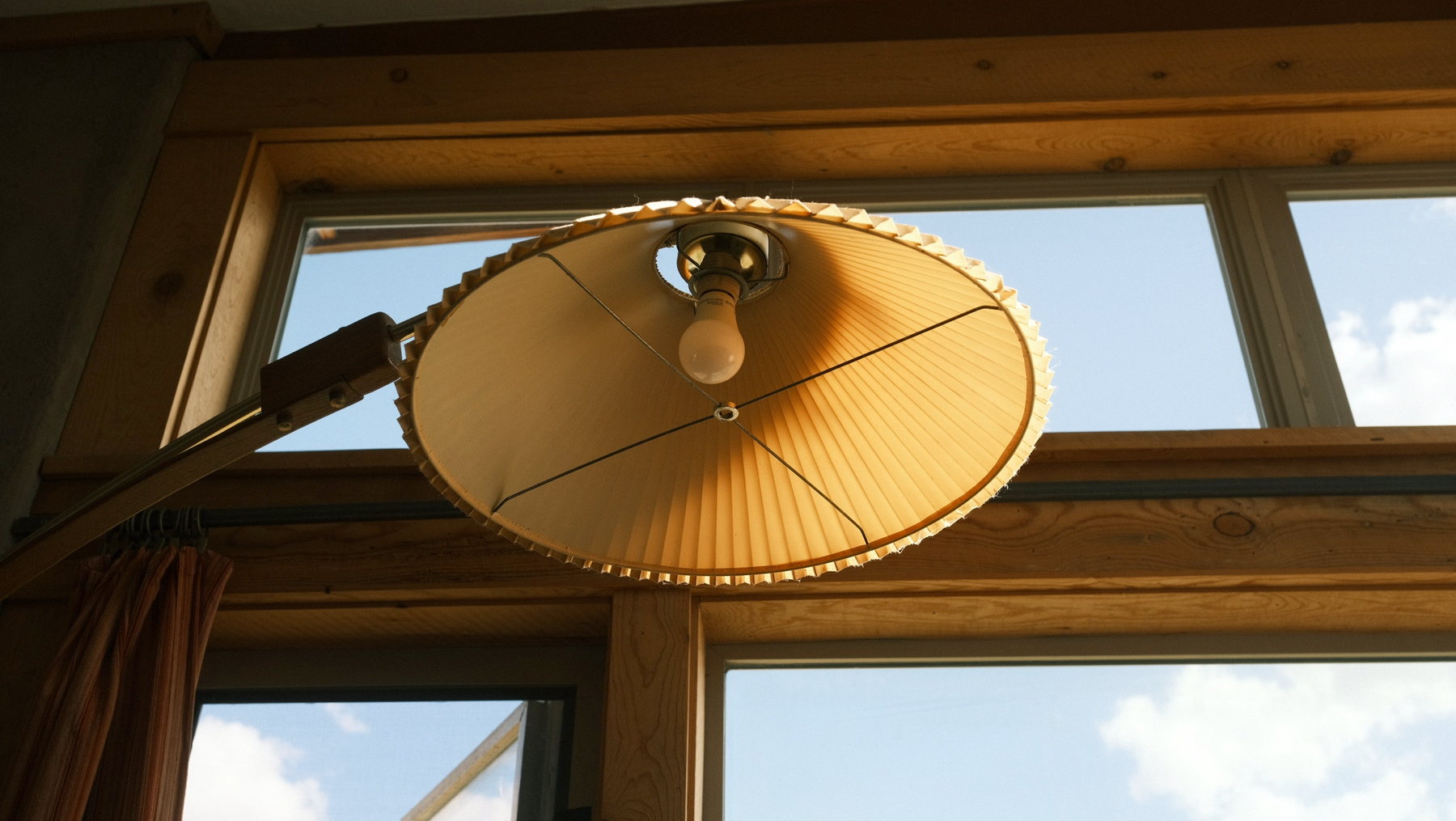 A photo of an unusual floor lamp taken from below as it sits infront of a window.
