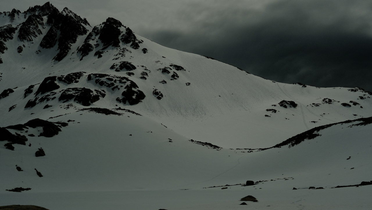 A snowy, mountainous landscape is seen under a dark, cloudy sky. (Argentina, 2023)