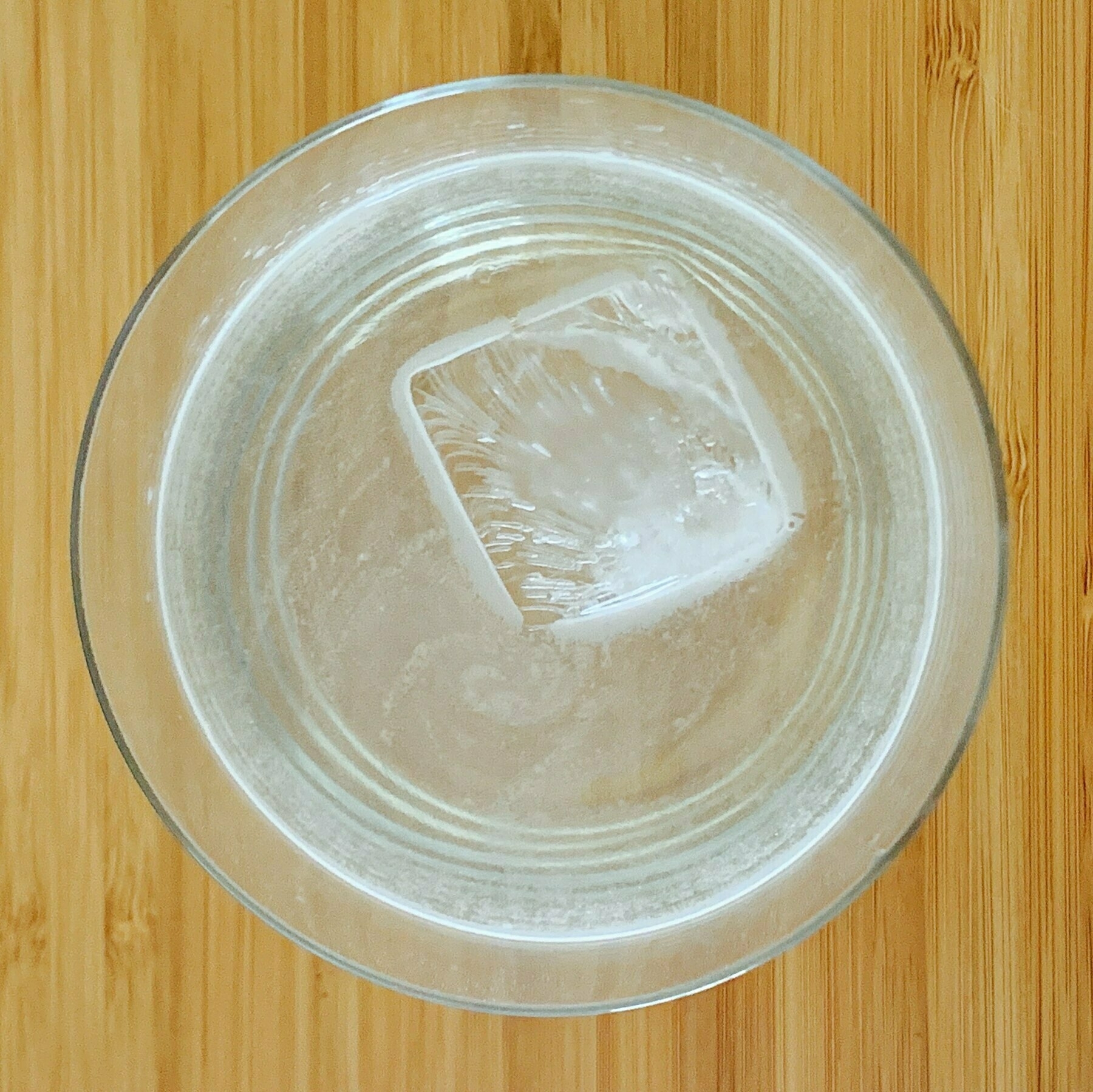 Top down look at a glass of water with an ice cube