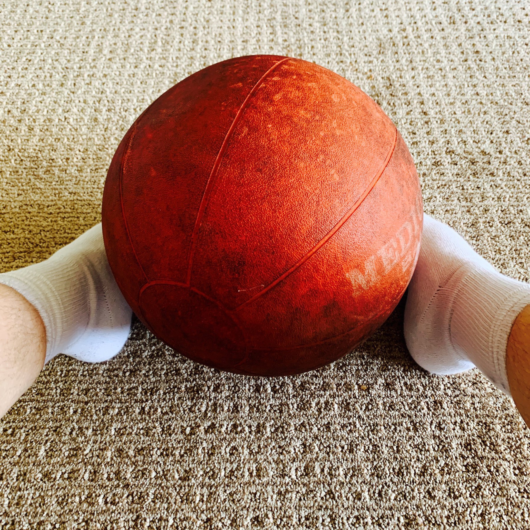 medicine ball resting between two feet