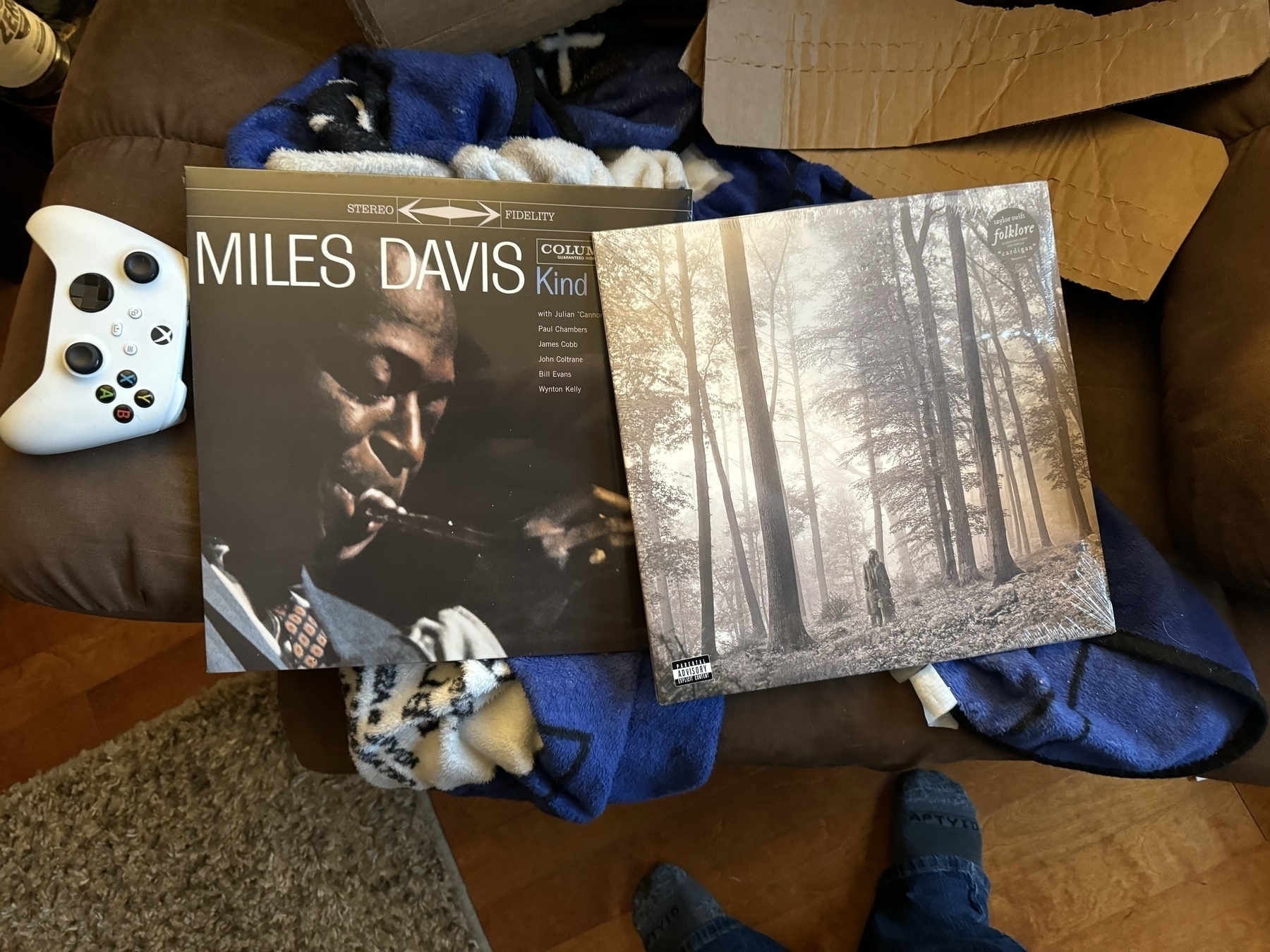 Miles Davis album Kind of Blue on vinyl and Taylor Swift Folklore on vinyl. 