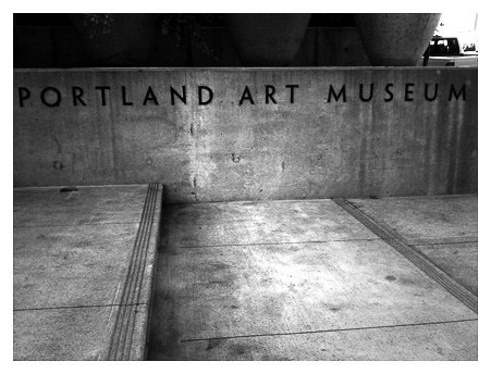 A concrete wall features the text Portland Art Museum in a black and white setting.