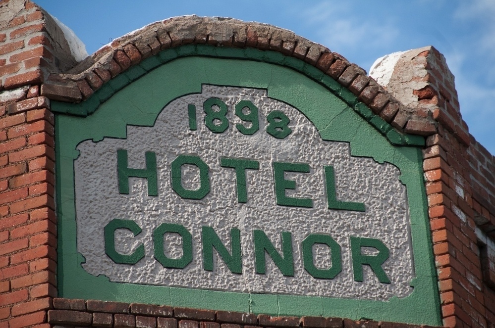 A historic-looking brick building facade features a sign for Hotel Connor, dated 1898.