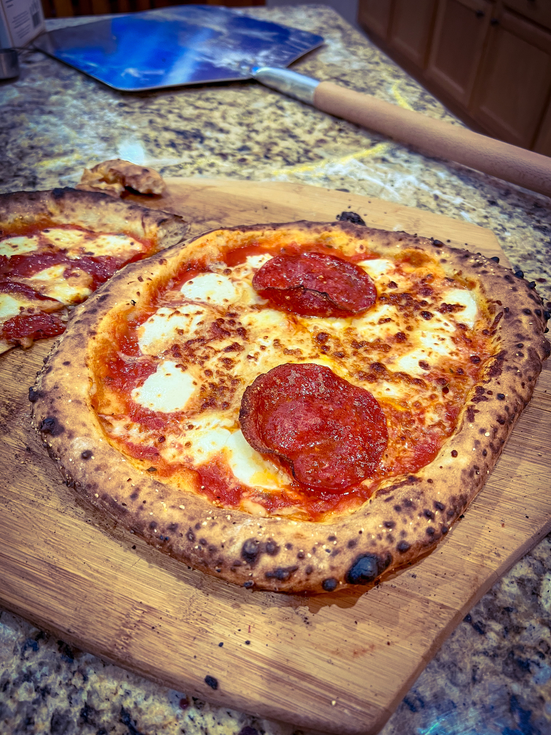 Auto-generated description: A freshly baked pizza with bubbling cheese and pepperoni slices sits on a wooden board, ready to be served.