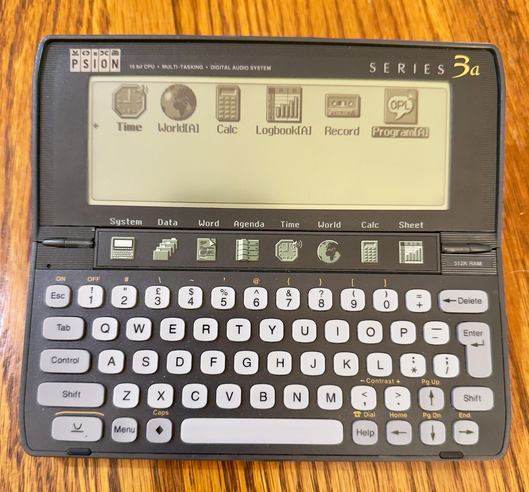 Auto-generated description: A Psion Series 3a personal digital assistant with a keyboard and screen displaying icons and text.
