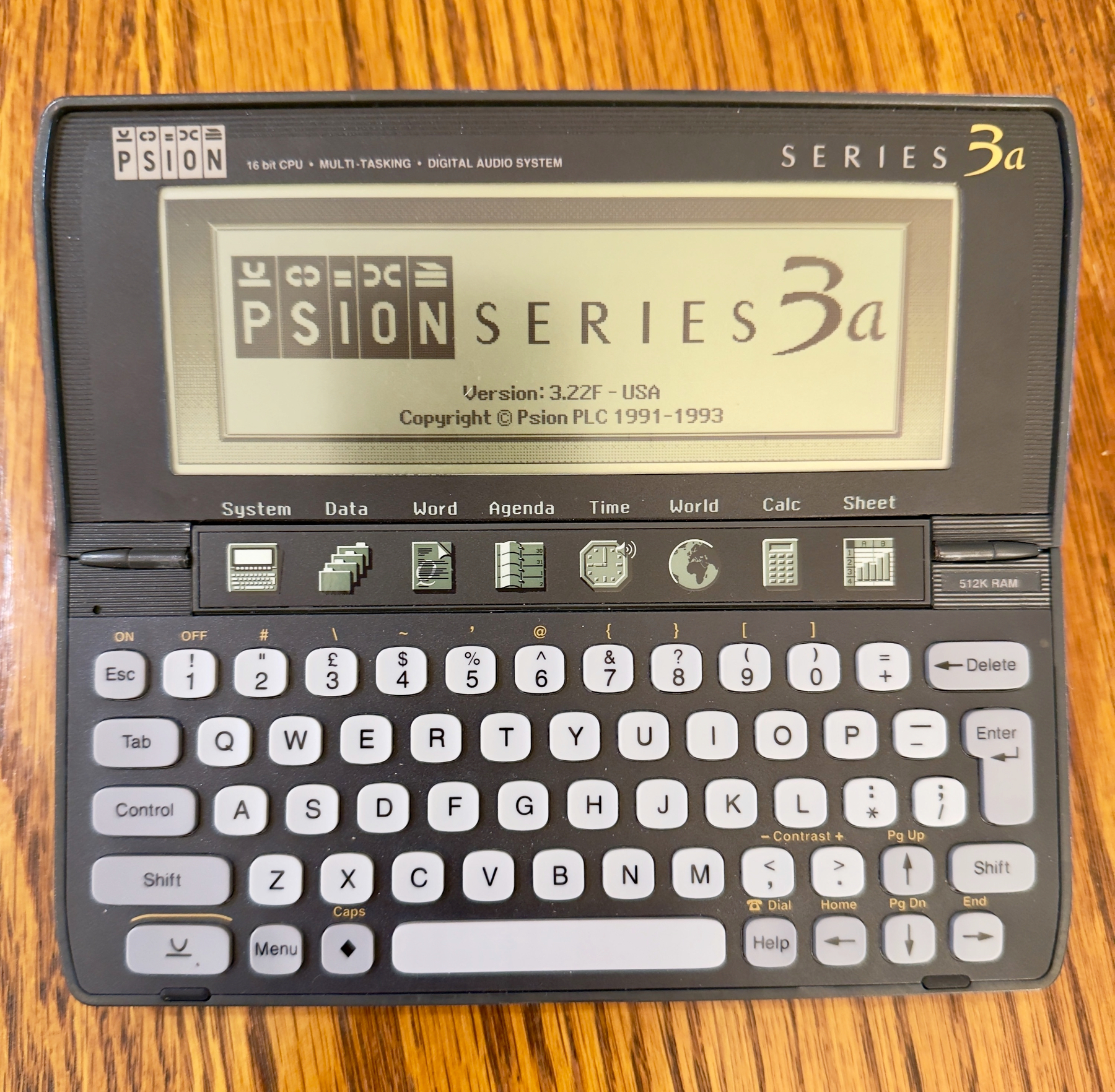Auto-generated description: A Psion Series 3a personal digital assistant is displayed with its screen showing the startup interface and a visible keyboard layout.