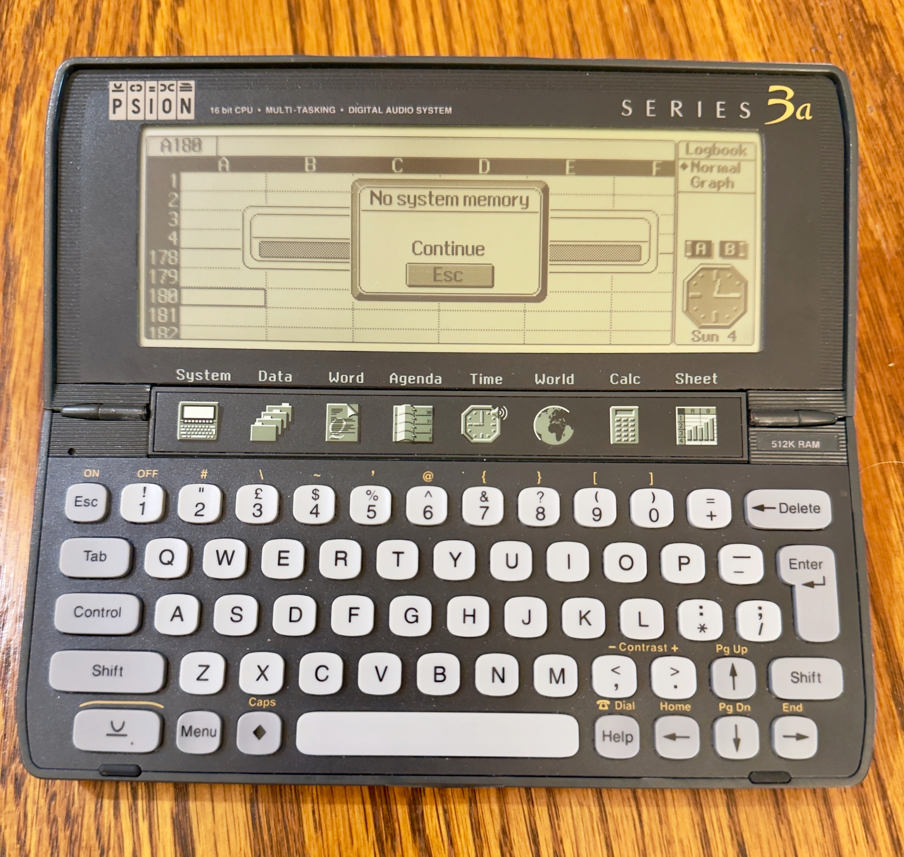 Auto-generated description: A vintage Psion Series 3a personal digital assistant is open, displaying a screen with a low memory warning.