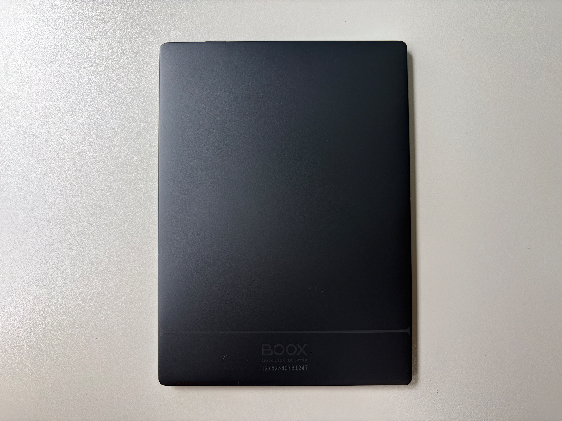 Auto-generated description: A closed black BOOX e-reader is placed on a plain white surface.
