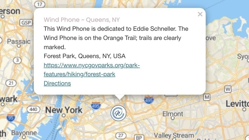 A map highlights the location of the Wind Phone in Forest Park, Queens, NY, with a dedication to Eddie Schneller and a link to more information.