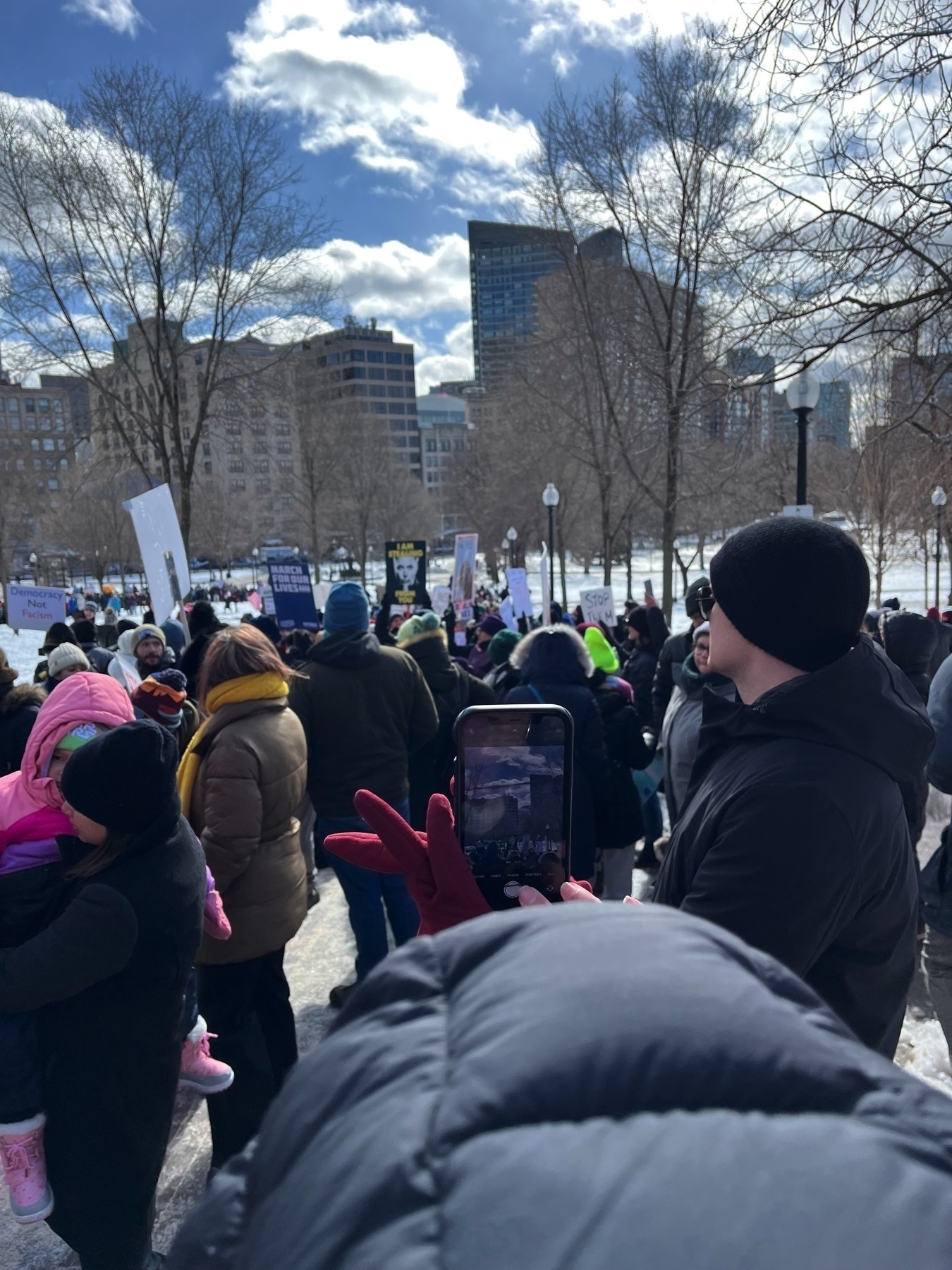 A view into the crowd, away from the State House. There is a big crowd of people.