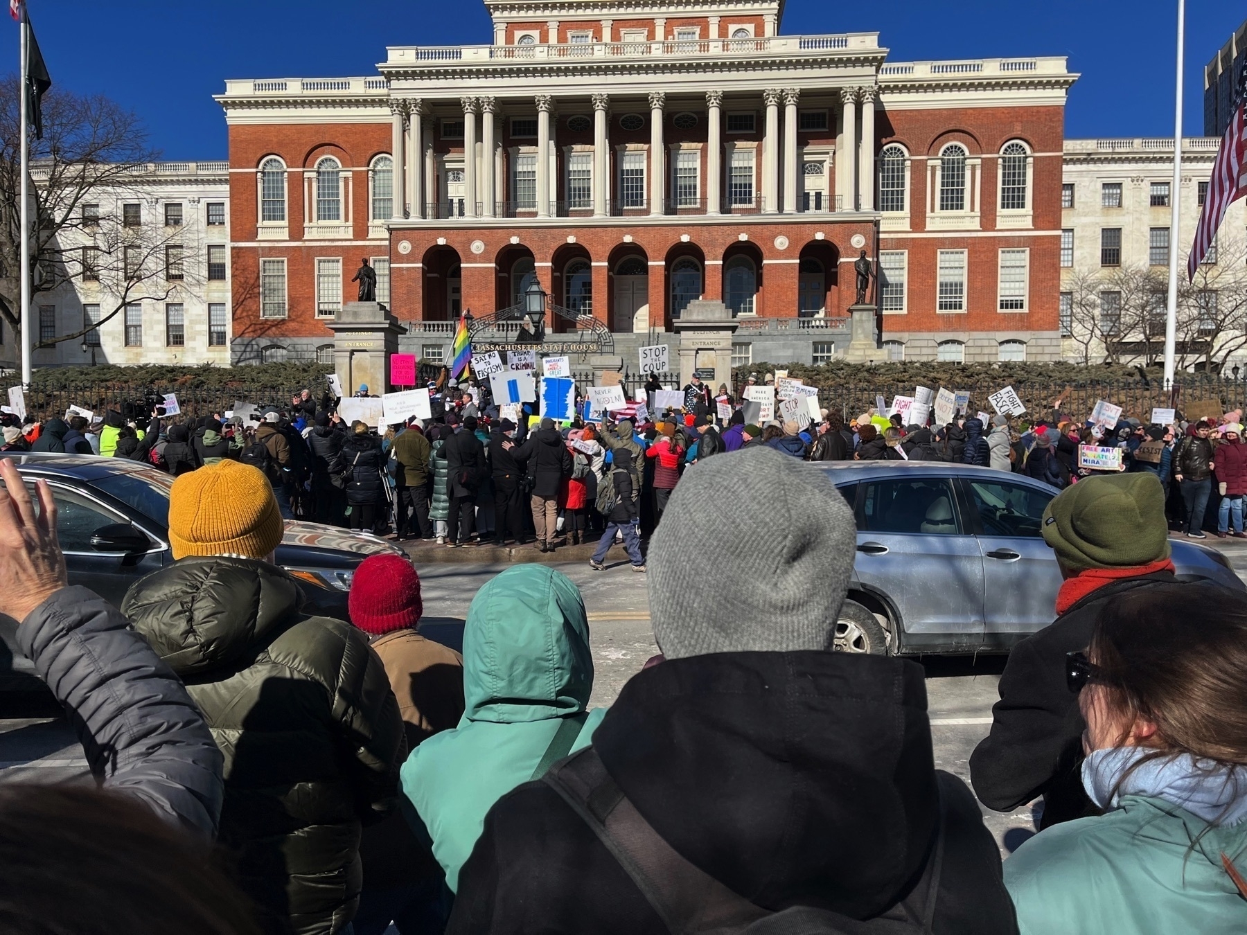 A good view of the state house. Some protesters right in front of it. Others were (with me) on the other side of the street. One sign says ”stop the coup.” Another says ”say no to fascism”.