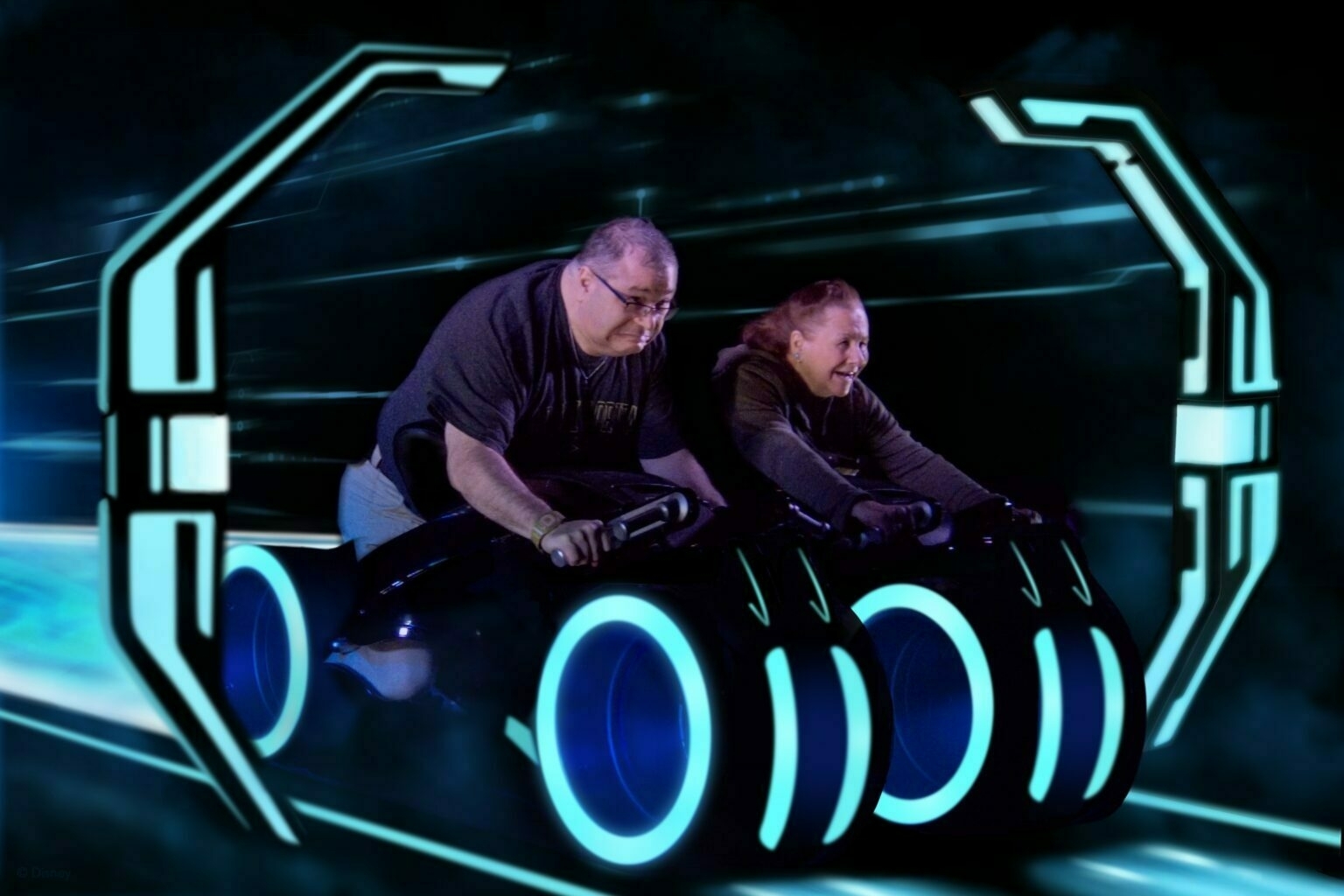 Two people are riding futuristic, glowing motorcycles in a neon-lit, digital environment.