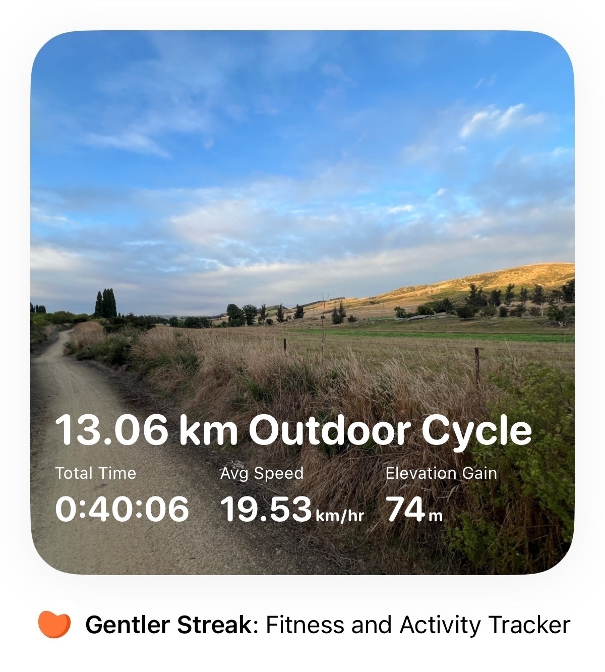 An activity card from the Gentler Streak app.  It shows a trail through grass and some sunset illuminated hills in the background. &10;&10;13.06km Outdoor Cycle