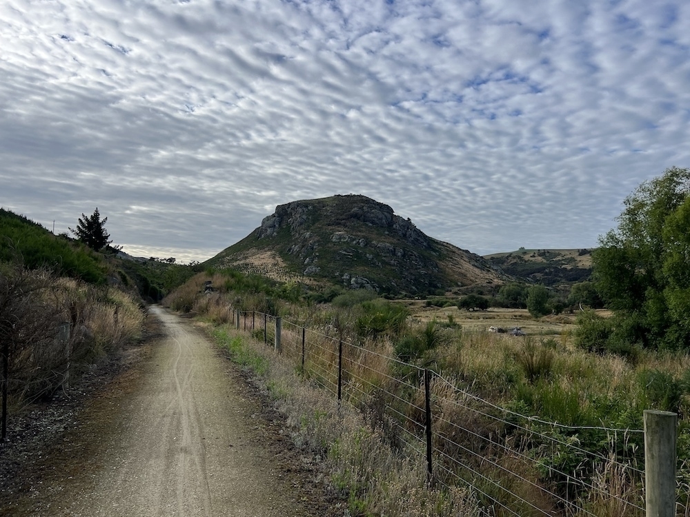 A bike trail extends into the distance around some scrubby hills