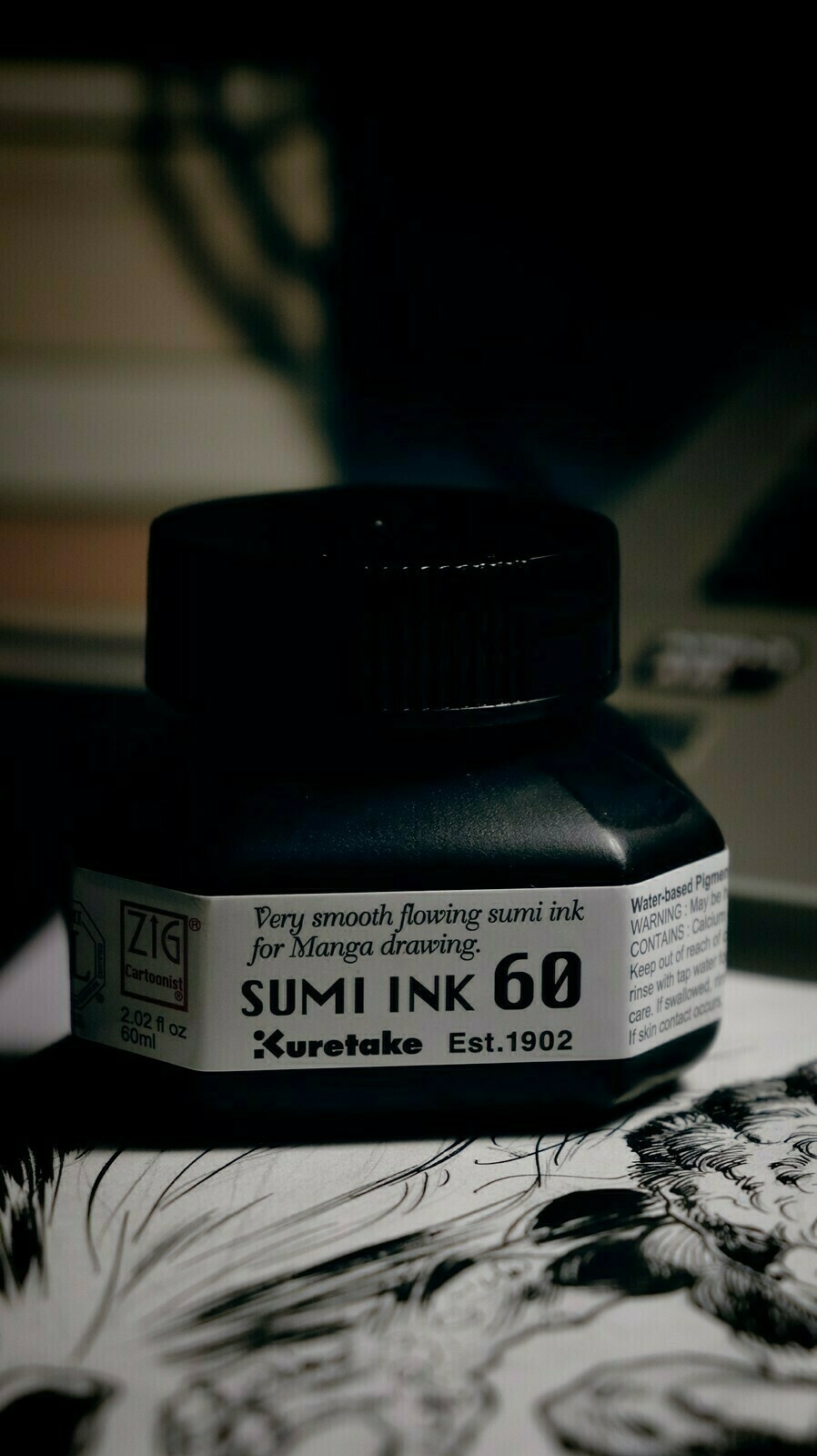 Photo of sumi ink bottle, label reads: Very smooth flowing sumi ink for Manga drawing. Sumi Ink 60. Kuretake, Est. 1902.