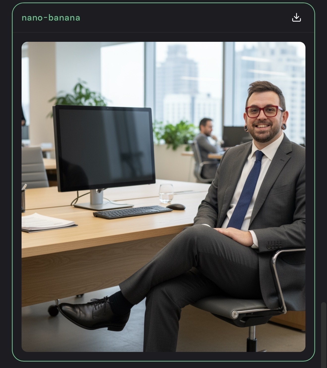 Auto-generated description: A man in a suit is sitting on an office chair beside a desk with a computer in a modern office setting.