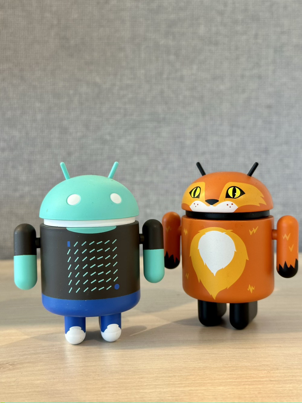 Photo of two little Android characters standing on a desk.