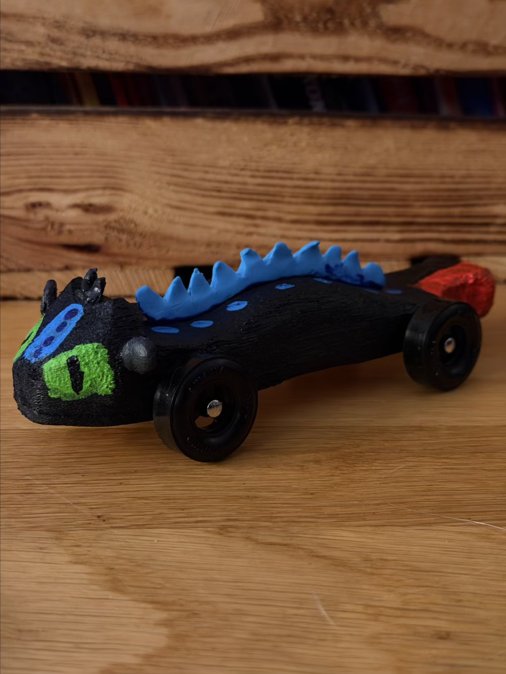 Picture of a pinewood derby car decorated to look like the dragon Toothless from the movie How to Train Your Dragon
