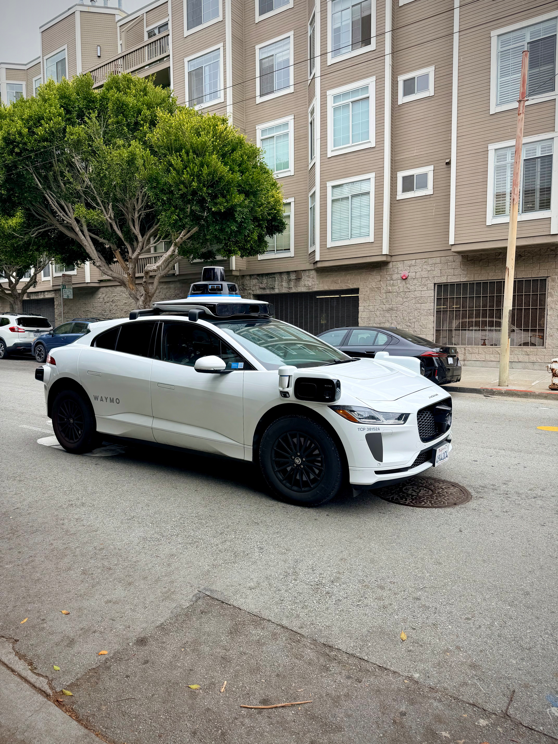 Outside shot of a Waymo car from the front passenger side.