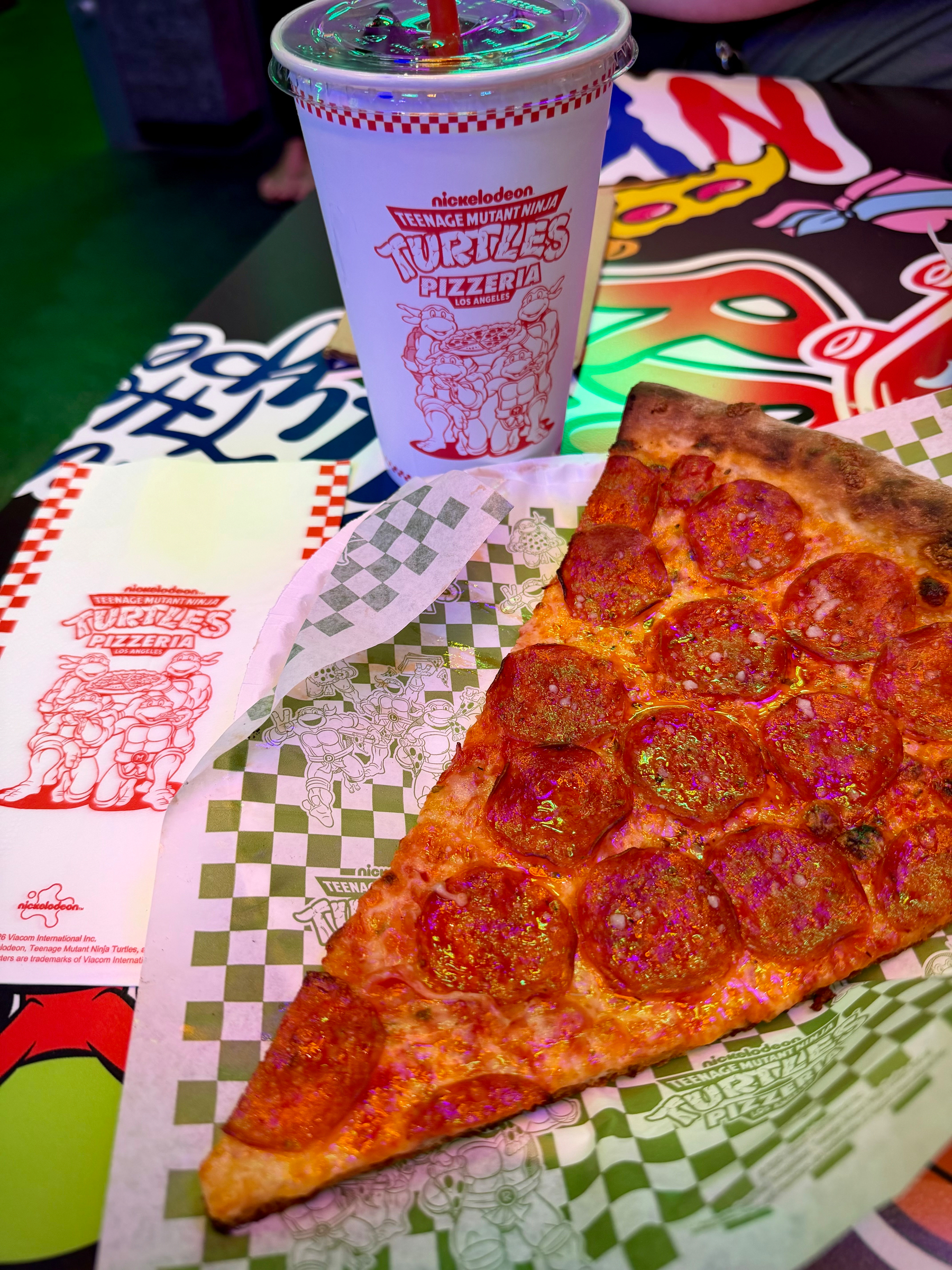 Pepperoni pizza with a drink and napkin.