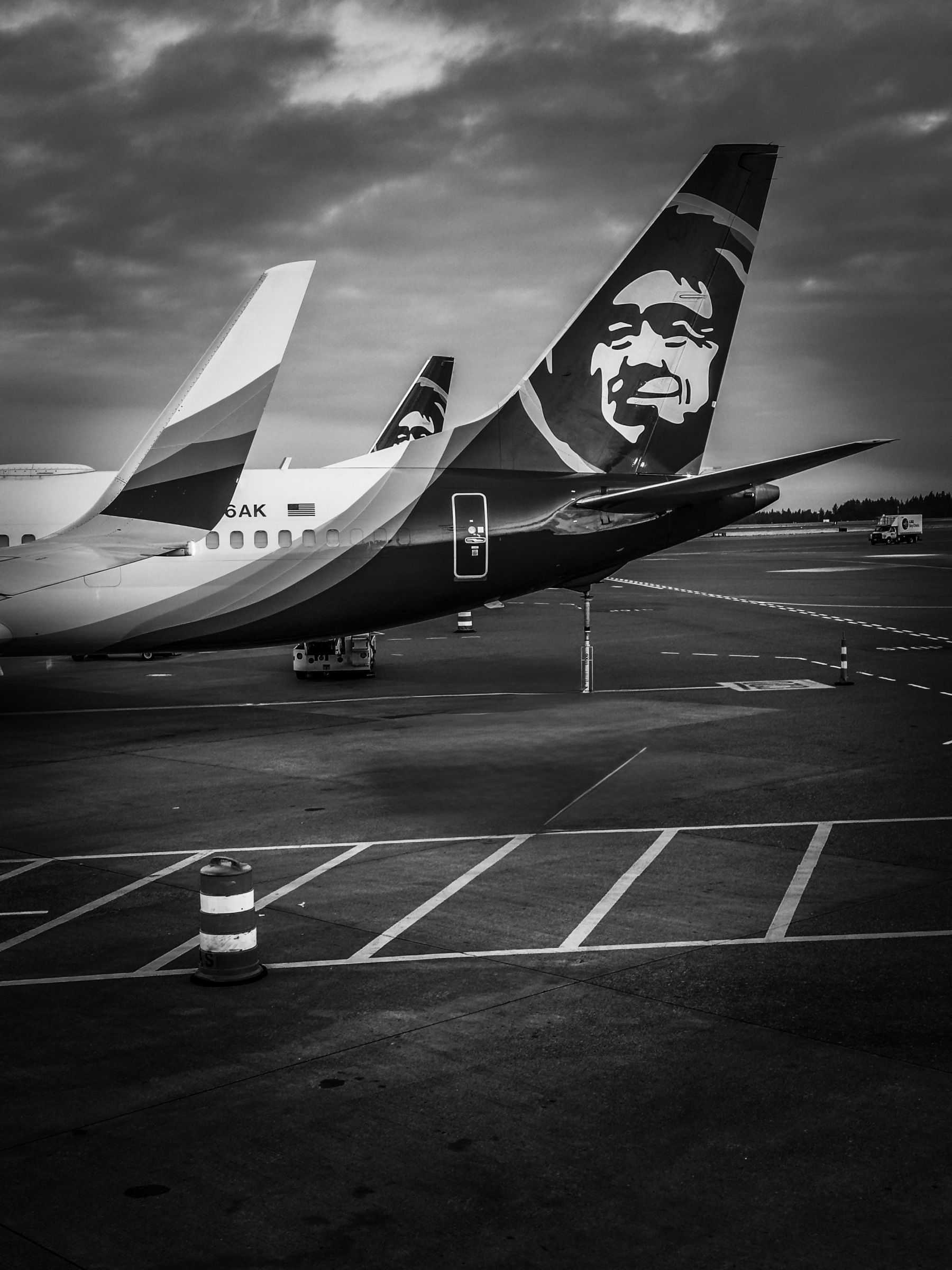 Auto-generated description: Three commercial airplane tails are parked at an airport, featuring distinct logos on their fins.