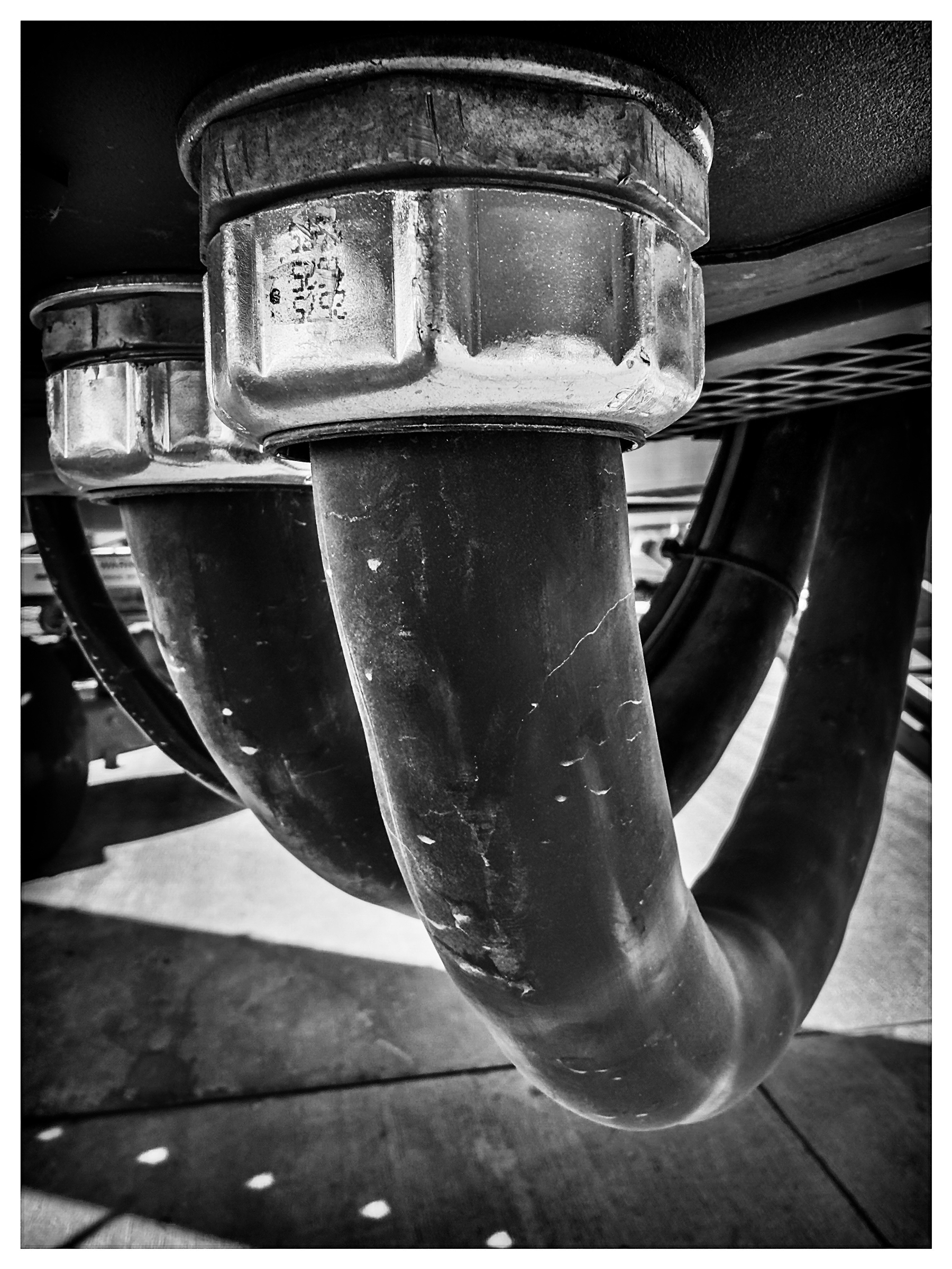Auto-generated description: A black and white close-up of large industrial pipes and fittings.