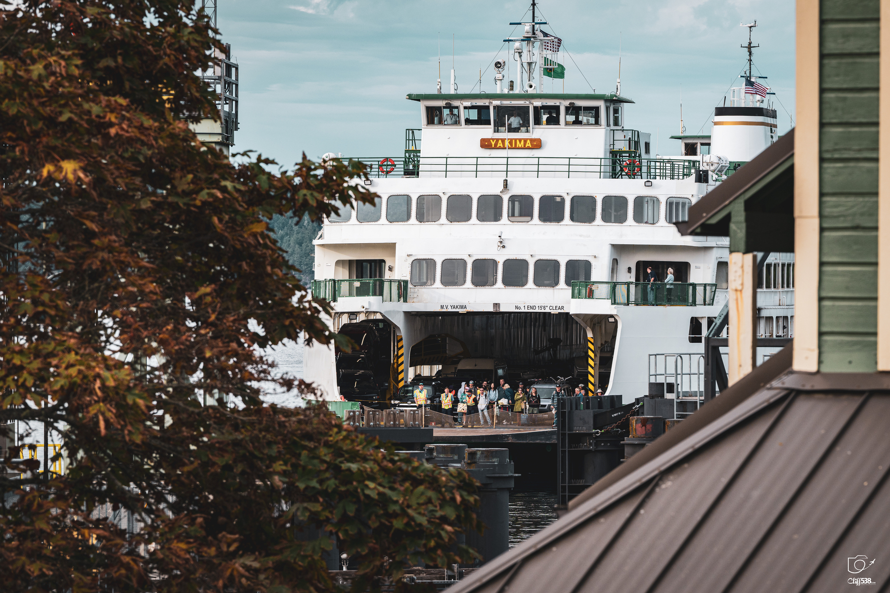 Auto-generated description: A large ferry named Yakima is docked at a pier with people gathered near its entrance.