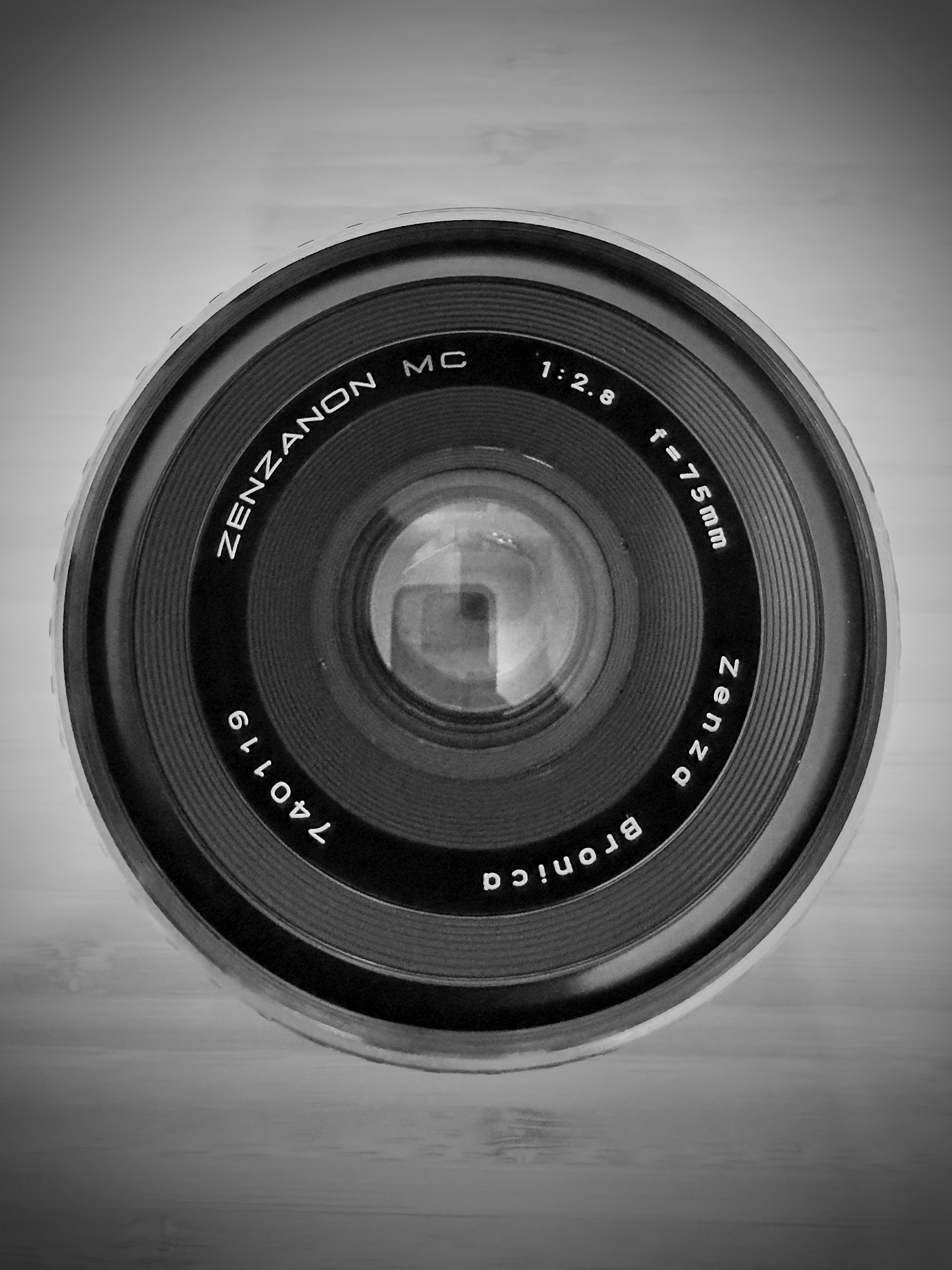 Auto-generated description: A close-up view of a Zenzanon MC camera lens is displayed, featuring specifications such as f/2.8 and 1:75mm.