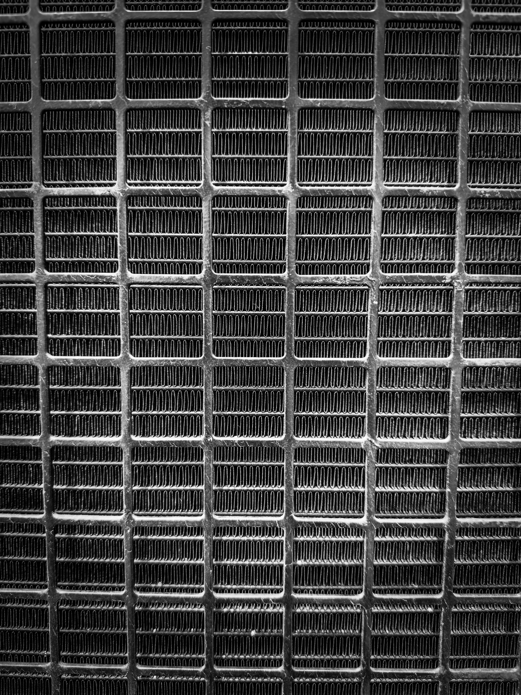 Auto-generated description: A grid pattern of rectangular metallic vents is arranged in a repeating sequence.