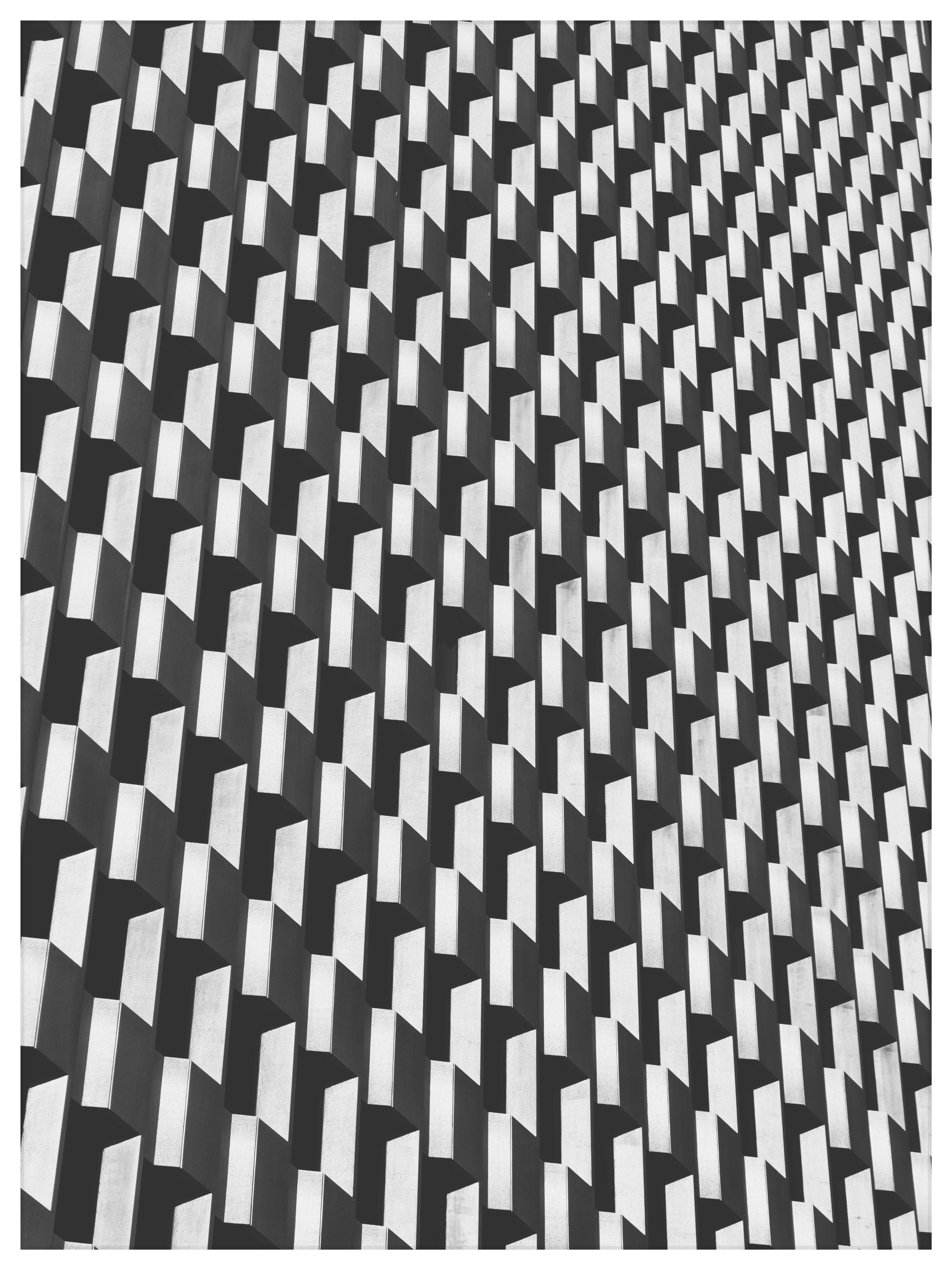 Auto-generated description: A geometric pattern featuring a repeating series of 3D rectangular shapes creates an optical illusion effect.