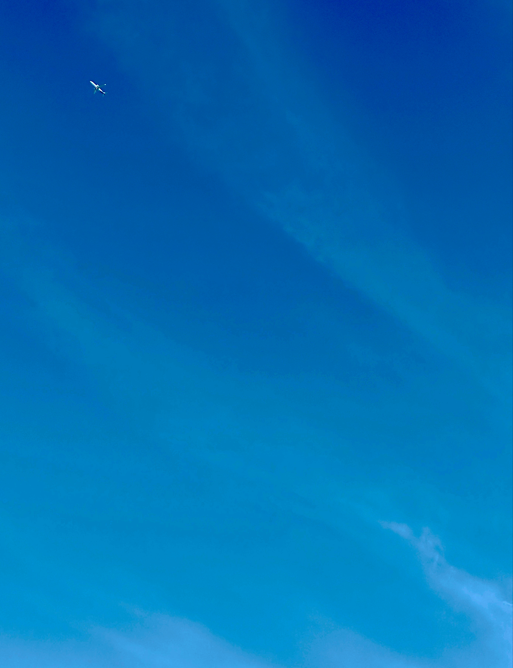 Auto-generated description: A small airplane is flying high in a clear blue sky.