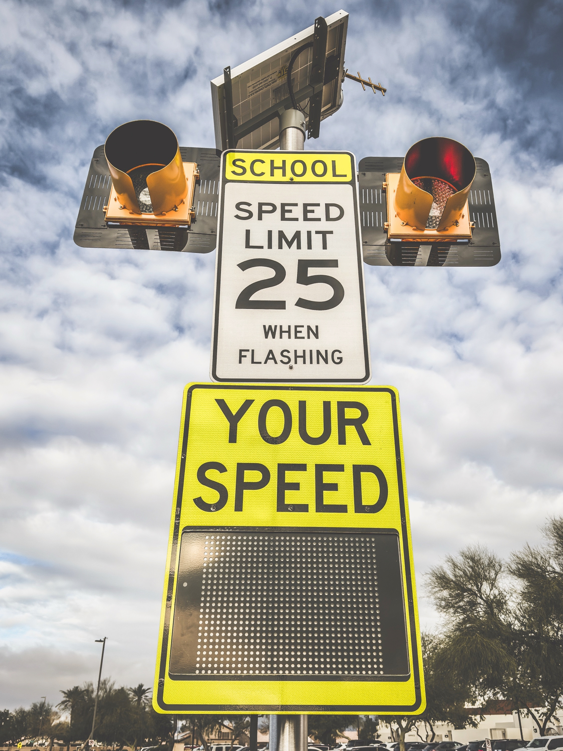 Auto-generated description: A school zone speed limit sign indicates a speed limit of 25 when flashing, accompanied by a digital speed display panel.