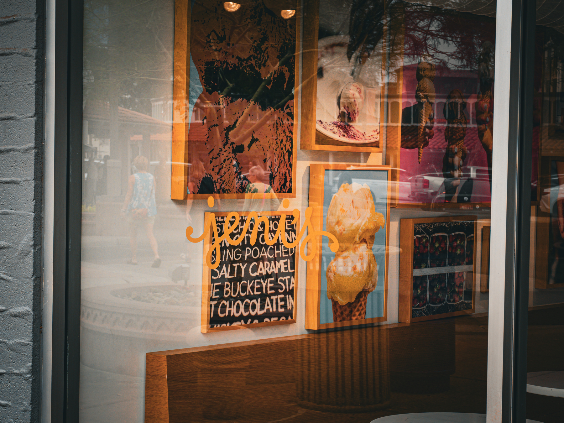 A storefront displays colorful artwork and signs related to ice cream.