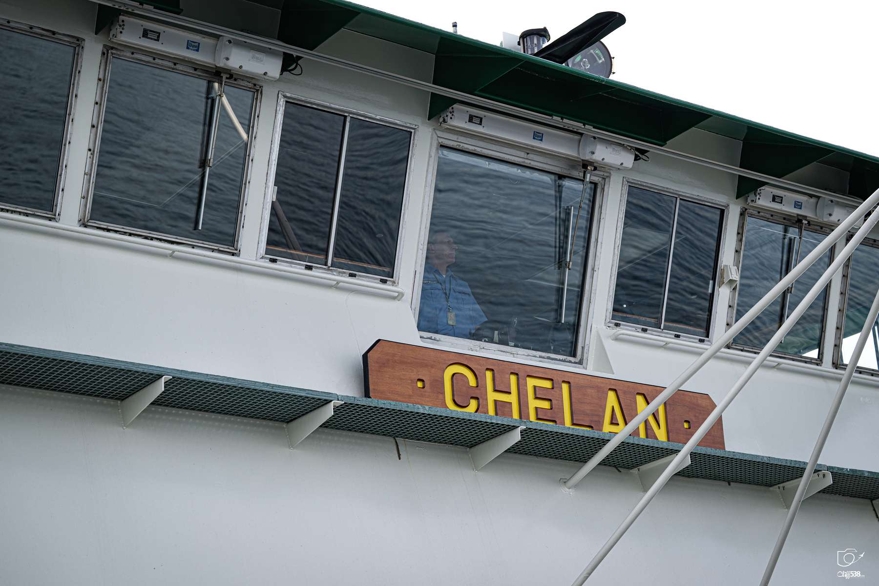 Auto-generated description: A person is visible inside the cabin of a boat named CHELAN.