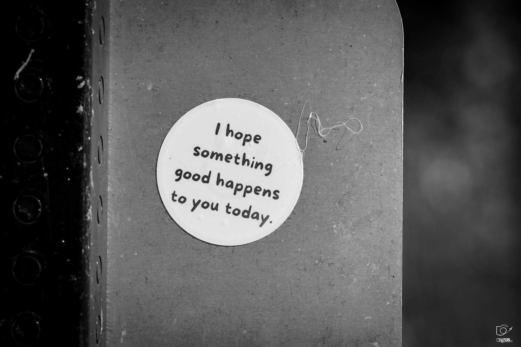 Auto-generated description: A round sticker with the message I hope something good happens to you today is attached to a textured surface.