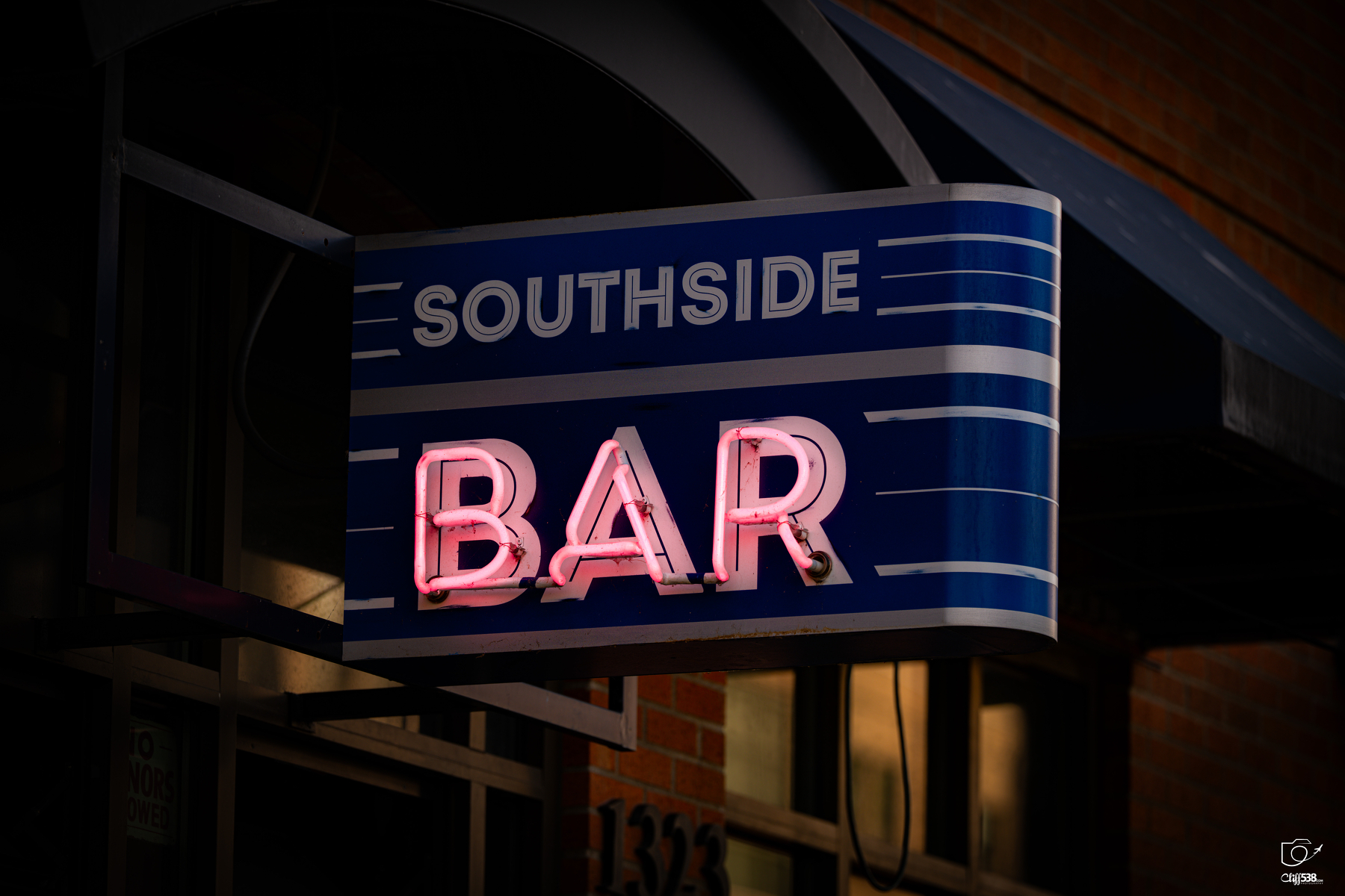 Auto-generated description: A neon sign displaying SOUTHSIDE BAR is attached to the exterior of a building.