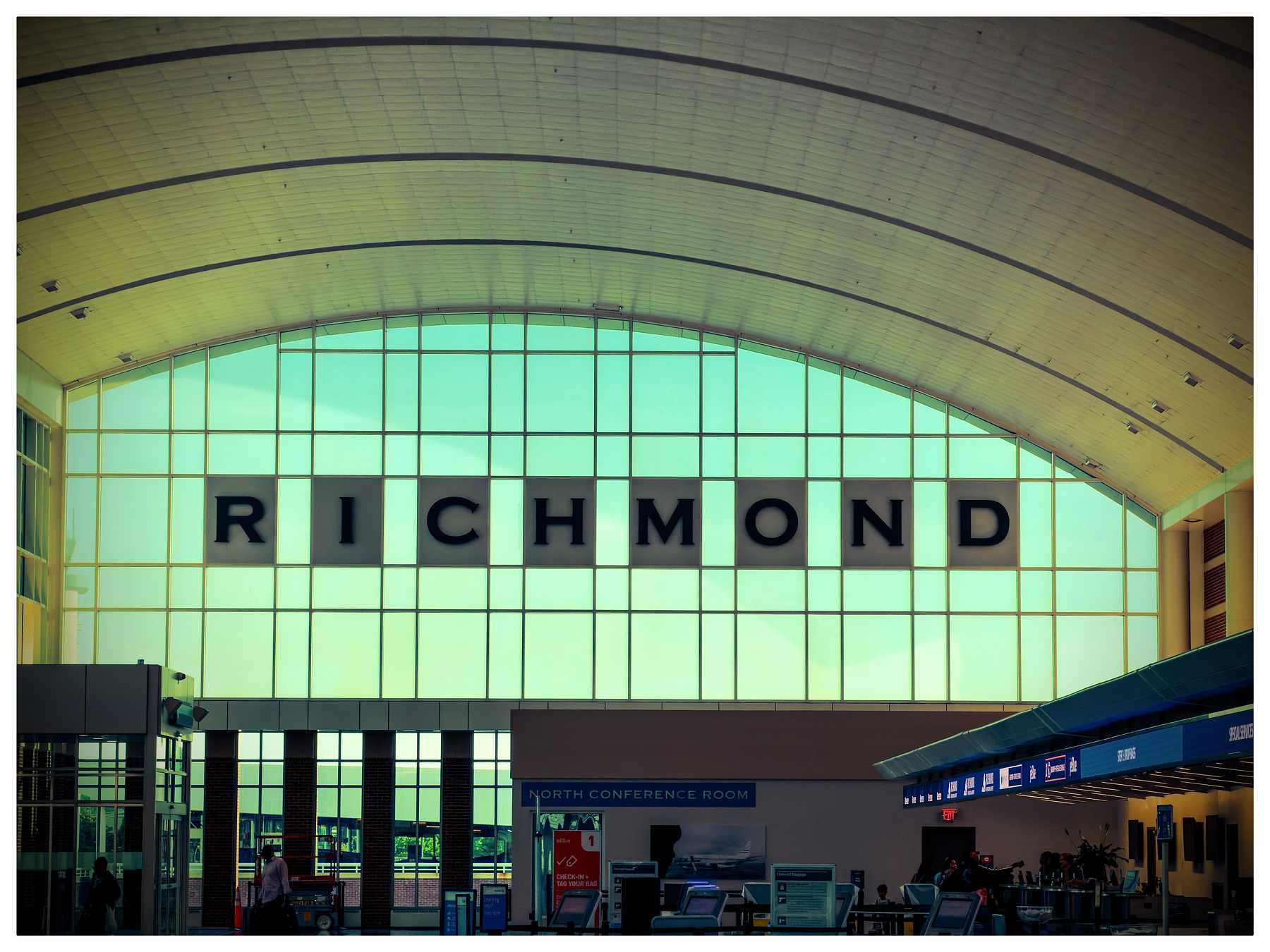 Auto-generated description: A large window at an airport terminal displays the word RICHMOND in big, bold letters.