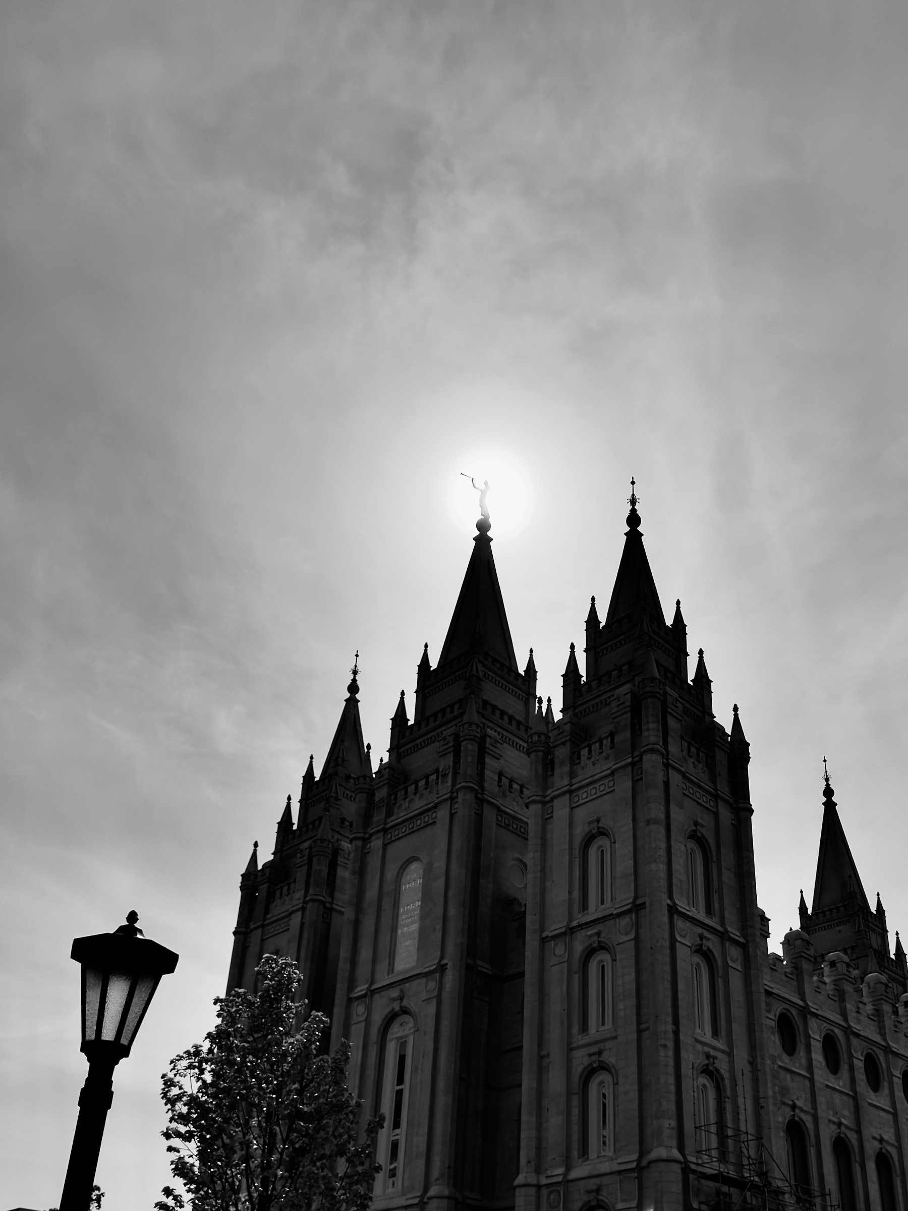 Auto-generated description: A towering, historic-looking building with multiple spires is silhouetted against a bright sky.