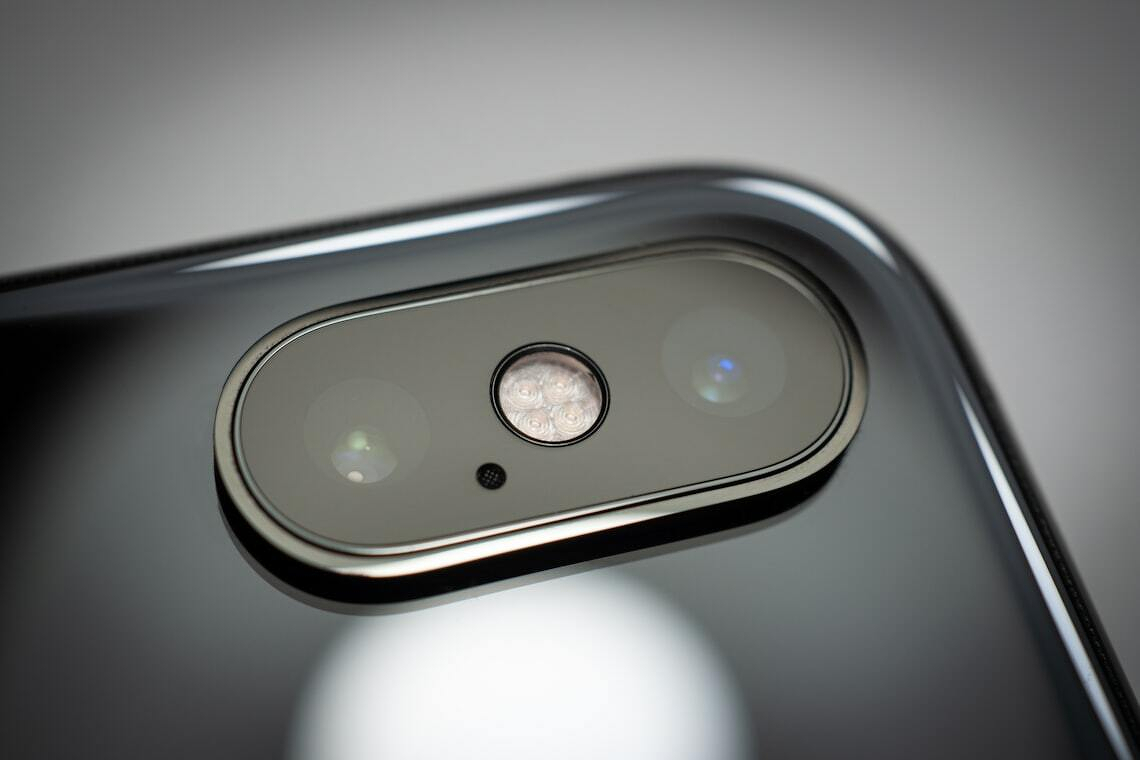 Auto-generated description: A close-up of a smartphone's dual camera module with a glossy surface and visible flash.