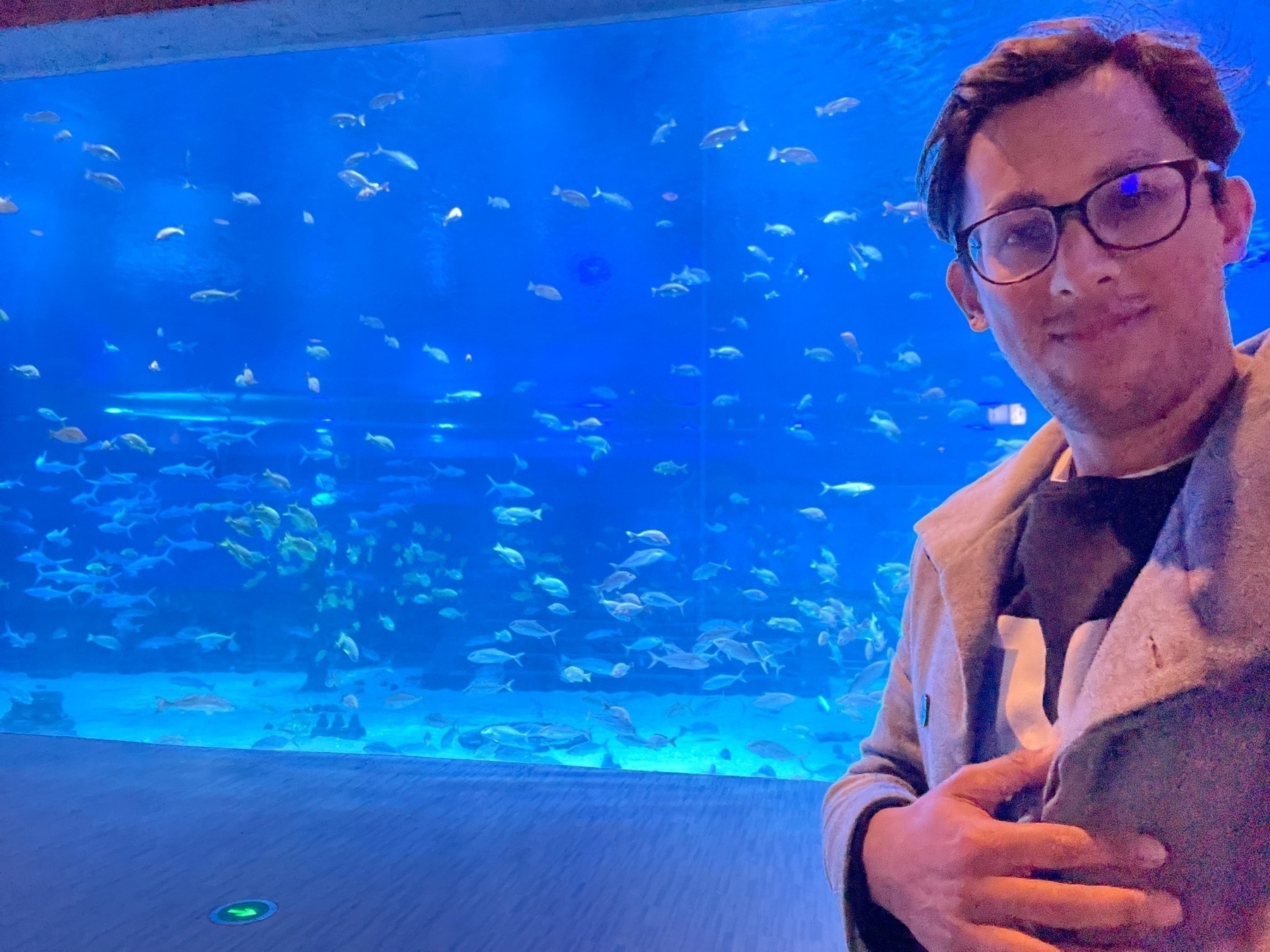 Selfie in front of a large aquarium tank 