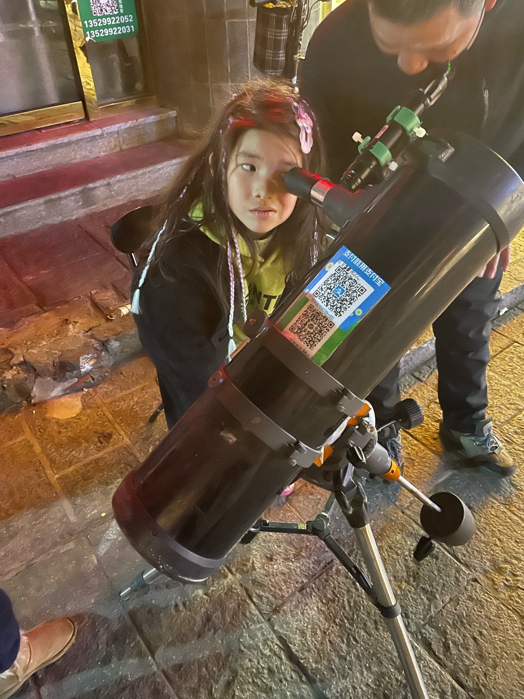 Girl looking through a telescope 