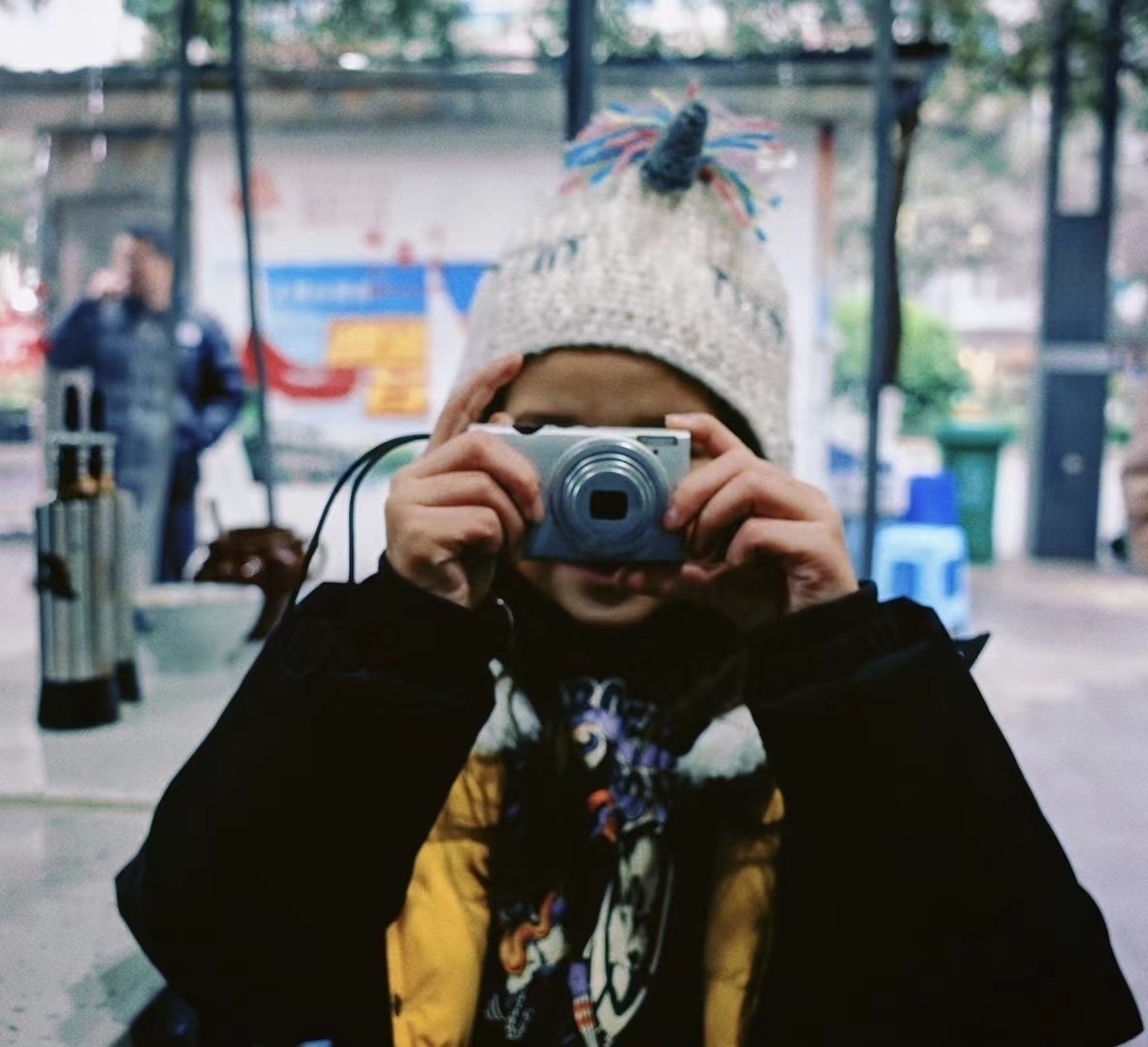 Girl taking a photo, with camera in front of her face